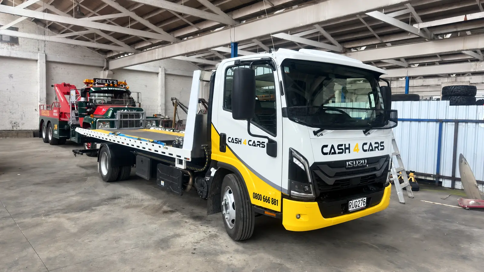 Cash 4 Cars branded Isuzu flatbed truck at the vehicle yard
